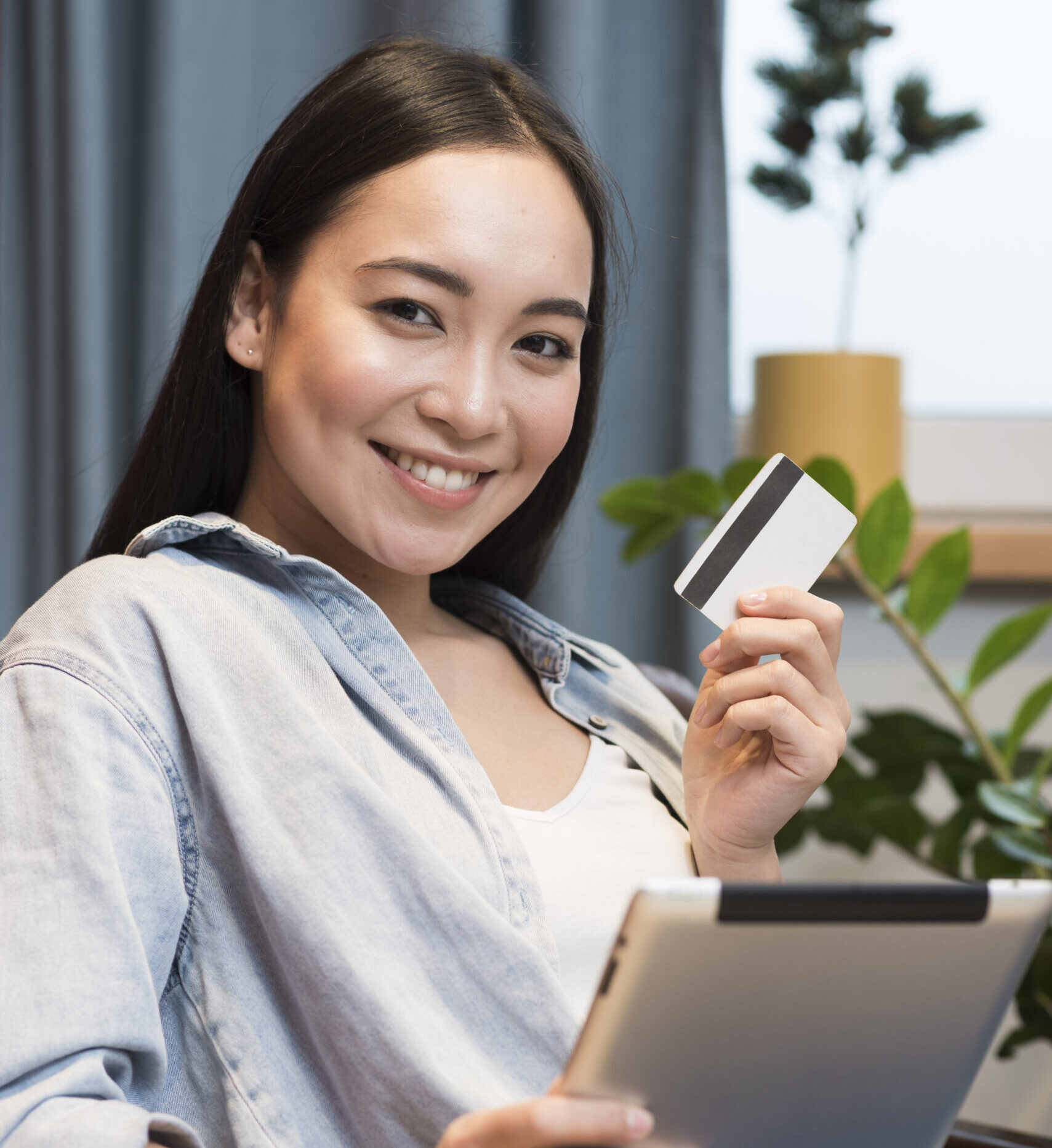 smiley-woman-posing-while-holding-tablet-credit-card